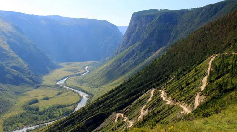 山坡上的山路和峡谷下的河流摄影图片