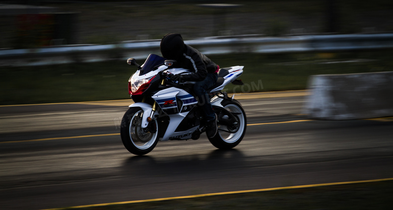 公路上疾驰的摩托车手摄影高清图片
