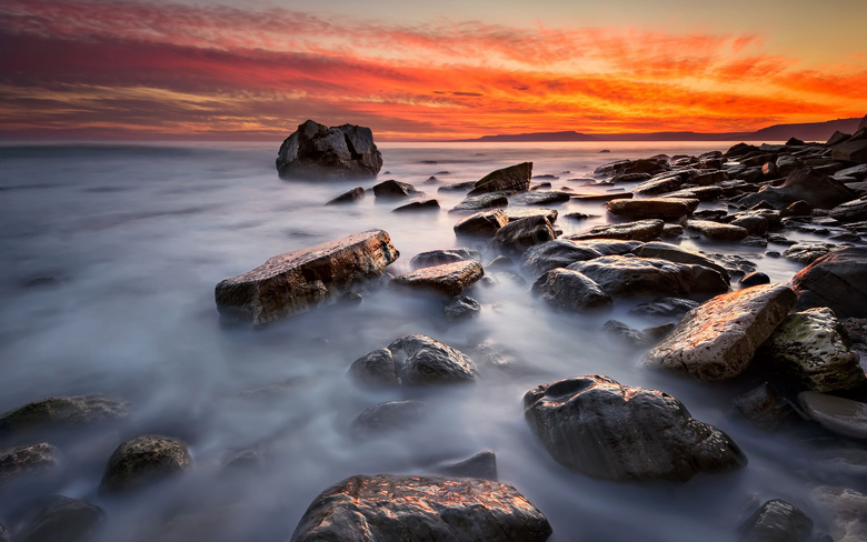 黄昏下海边岩石和海边美景摄影图片