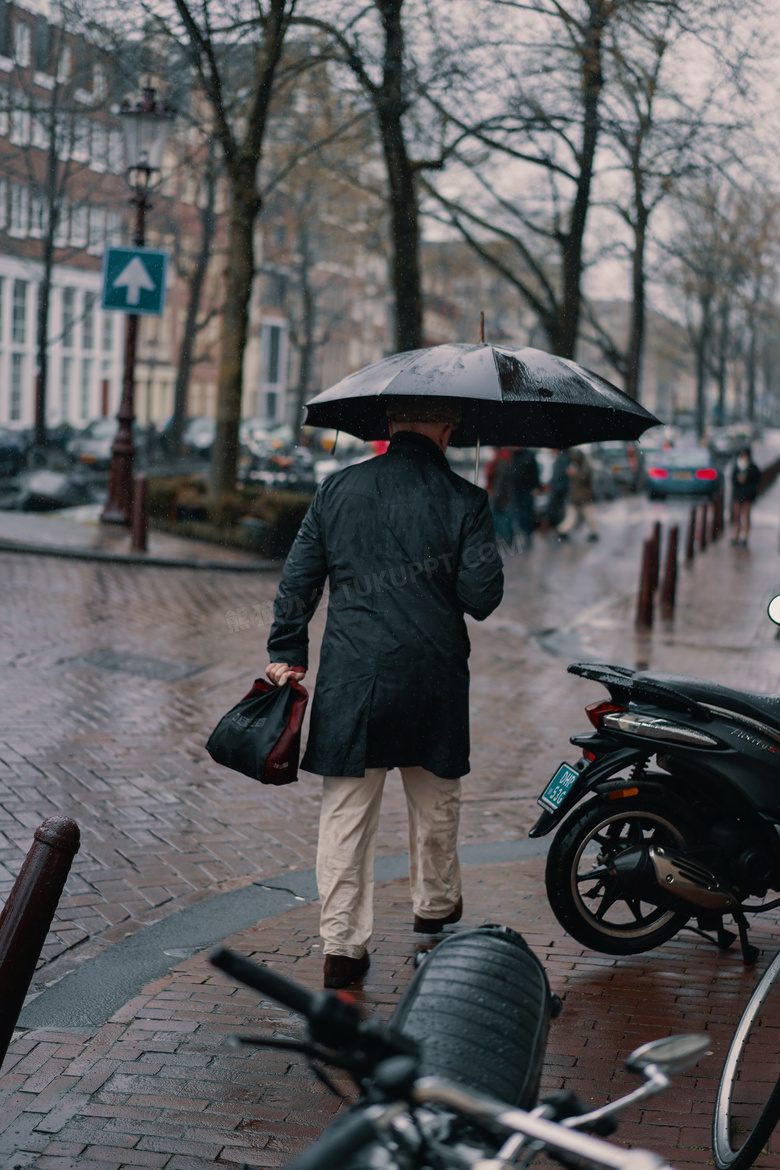 男人雨中撑伞背影图片