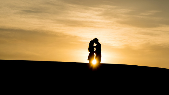 夕阳下拥抱的情侣剪影摄影图片