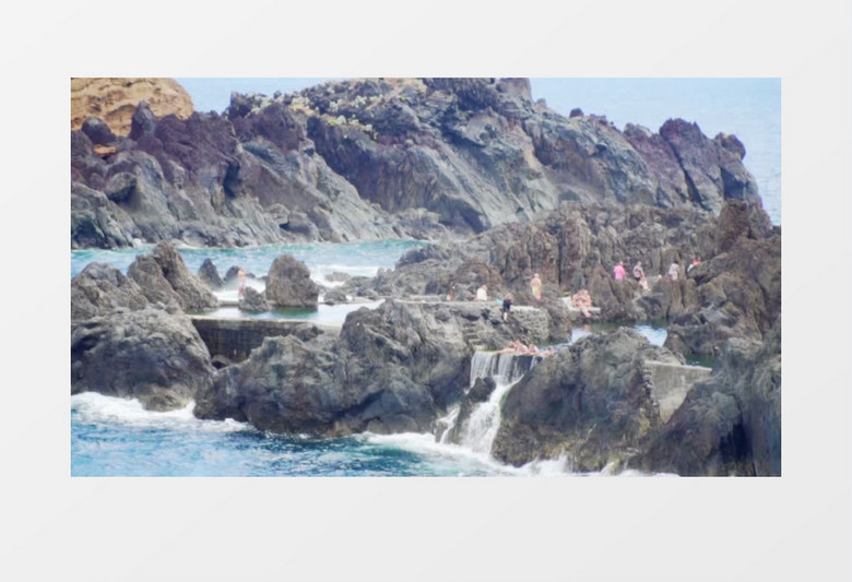 游客行走在海边岩石实拍视频