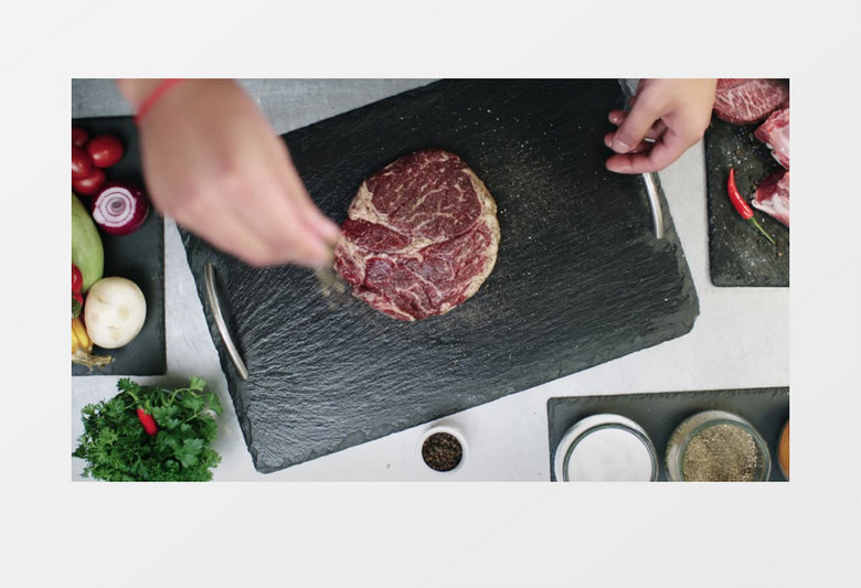 厨师在案板的牛肉上放调料实拍视频素材