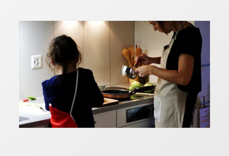 小女孩在厨房帮妈妈做饭实拍视频素材