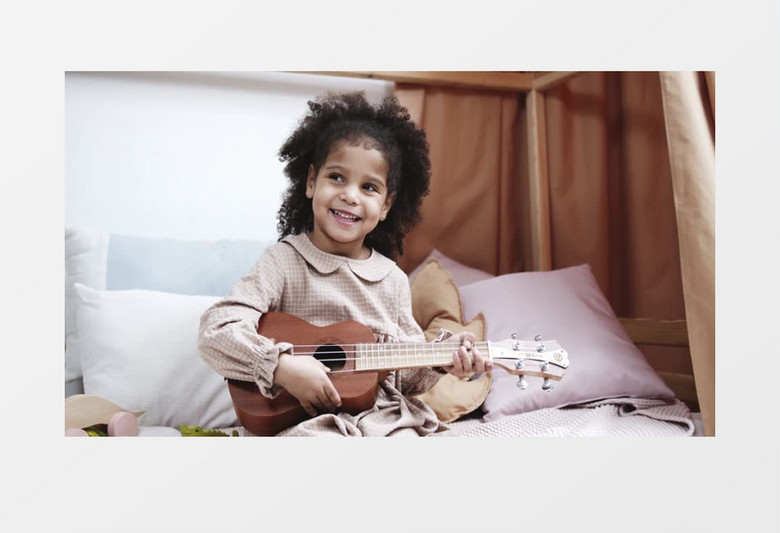 小女孩在开心的弹吉他实拍视频素材