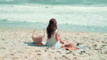 碎花裙女孩坐在沙滩上看海实拍视频素材