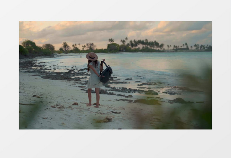 女孩在海边沙滩上放下背包实拍视频素材