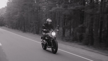 全景拍摄男子在公路上骑摩托车实拍视频