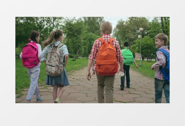 小学生们背着书包有说有笑的放学回家实拍视频素材