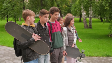一群中学生拿着滑板走在放学回家的路上实拍视频素材