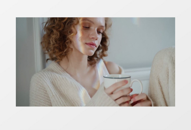 女人抱着杯子坐着实拍视频素材