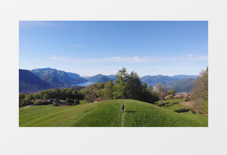 郊区嫩绿的草地和远处壮丽山河实拍视频素材