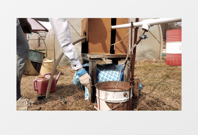 人在水龙头下放水桶接水实拍视频素材