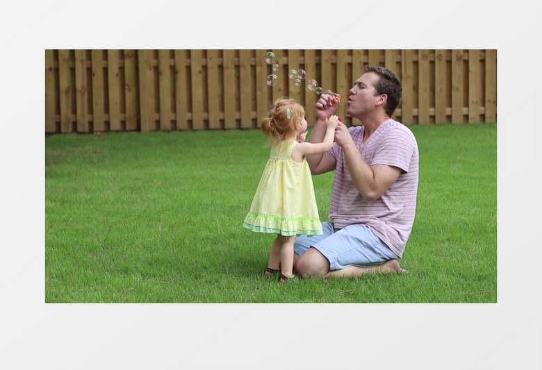 爸爸在陪女儿在草地上吹泡泡实拍视频素材实拍视频素材