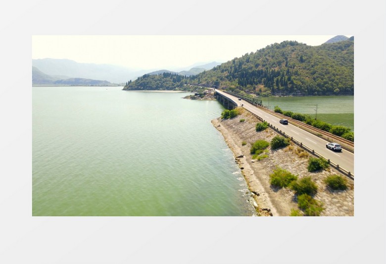 在山脚下的公路上不断行驶着汽车实拍视频素材