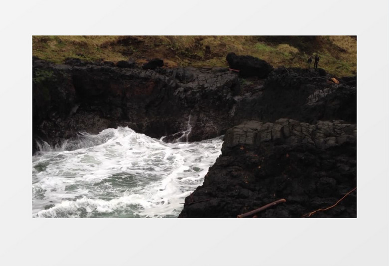 高清实拍山底岩石附近的海浪以及两个人在登山实拍视频素材
