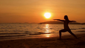 户外海滩沙滩边傍晚黄昏女性在运动锻炼佛教冥想实拍视频素材
