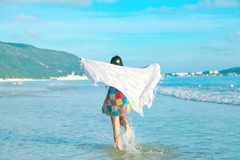 海边披着围巾沙滩上奔跑的美女摄影图片
