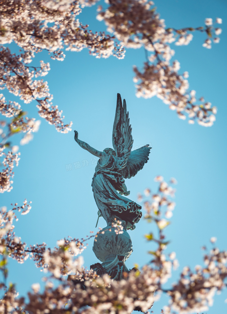 鲜花树枝衬托下的雕塑摄影高清图片