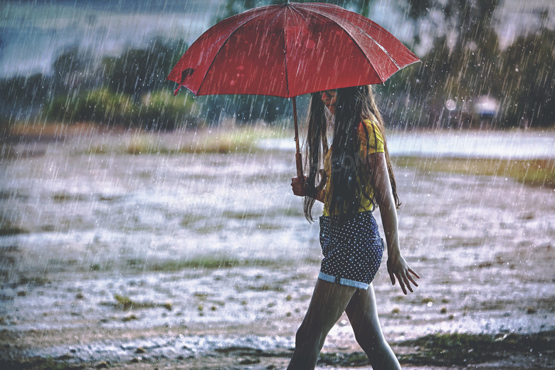 撑着伞走在雨中的长发美女摄影图片