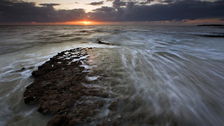 傍晚大海中的礁石摄影图片