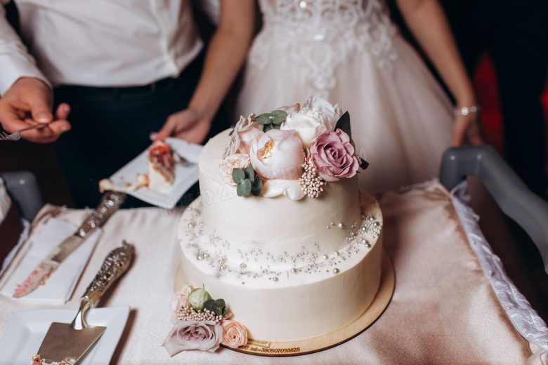 在桌上花朵装饰的婚庆蛋糕摄影图片