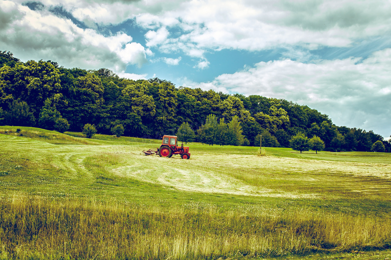 蓝天白云下的农场拖拉机摄影图片