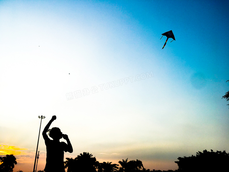 夕阳下放风筝的人物剪影摄影图片