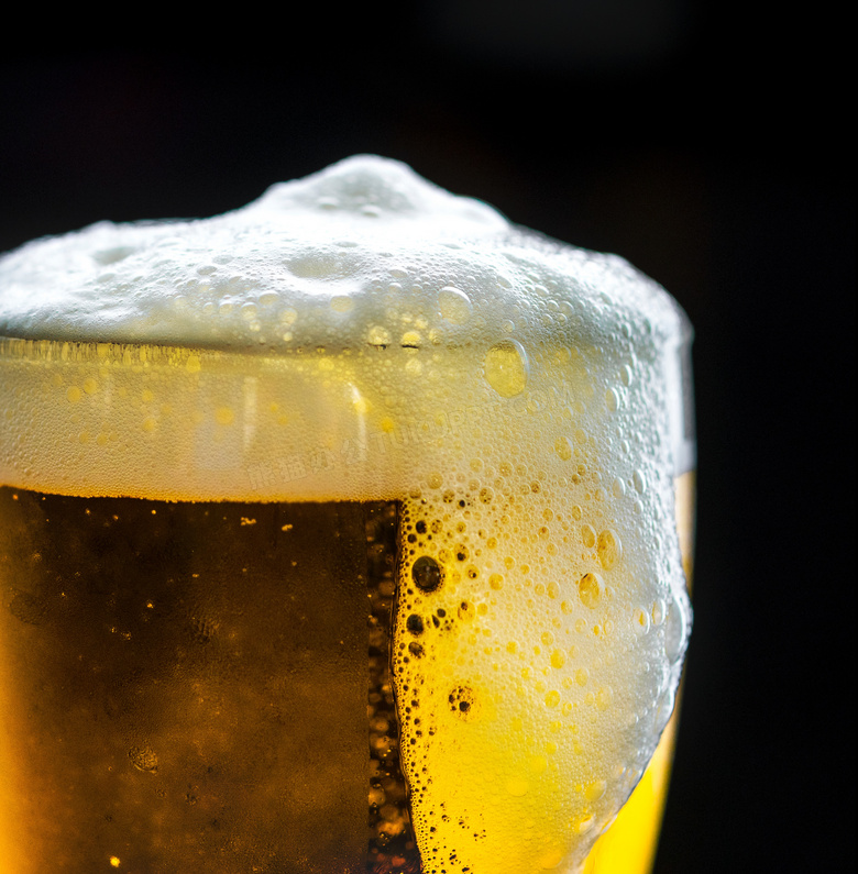 啤酒溢出的玻璃杯特写摄影高清图片