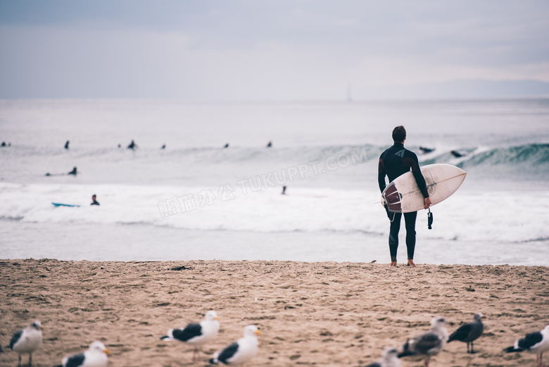 海边拿着冲浪板的男子摄影高清图片