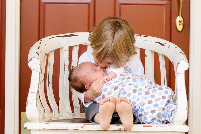 椅子上抱着宝宝的小孩摄影高清图片
