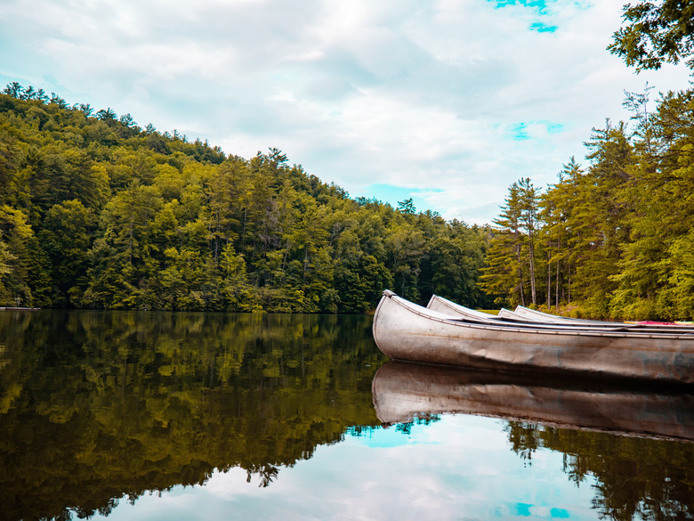 山间湖泊中停靠的小舟摄影图片
