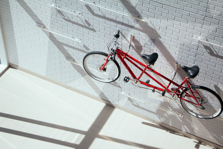 挂在砖墙上的红色单车摄影高清图片