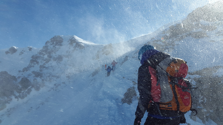 冒着风雪前行的登山者摄影高清图片