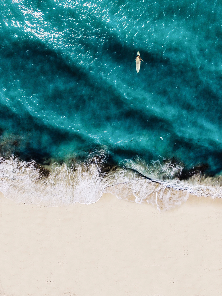 沙滩浪花与海上的小船摄影高清图片