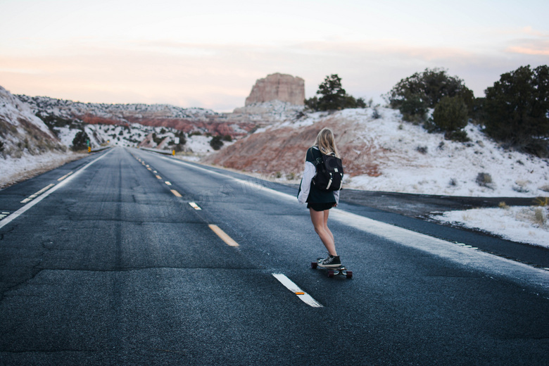 在公路上玩滑板的美女摄影高清图片