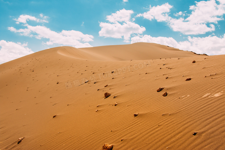蓝天白云与掺杂砾石的沙丘高清图片