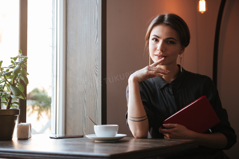 桌前抱着书的美女人物摄影高清图片