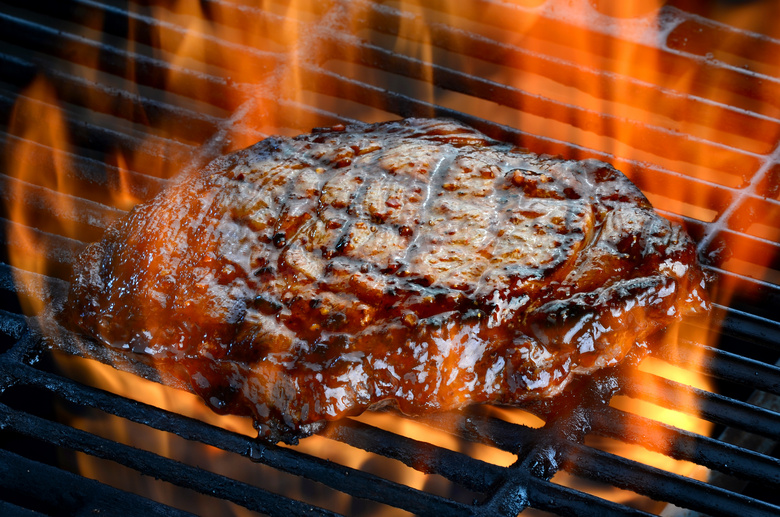 在大火烤制的美味牛排摄影高清图片