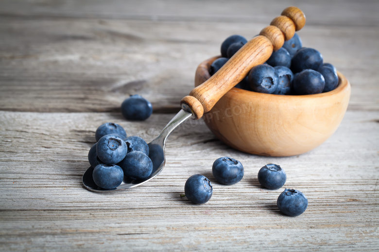 木柄勺与木碗中的蓝莓摄影高清图片