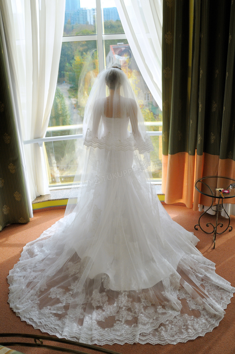 站在窗前的长拖尾婚纱新娘高清图片