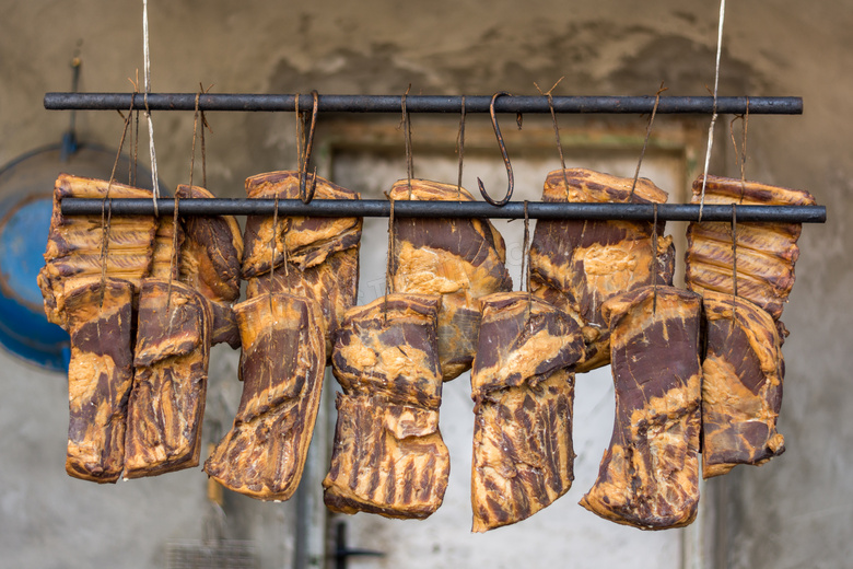 悬挂成两排晾晒的腊肉摄影高清图片
