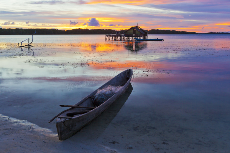 黄昏下湖边停泊的小舟摄影图片