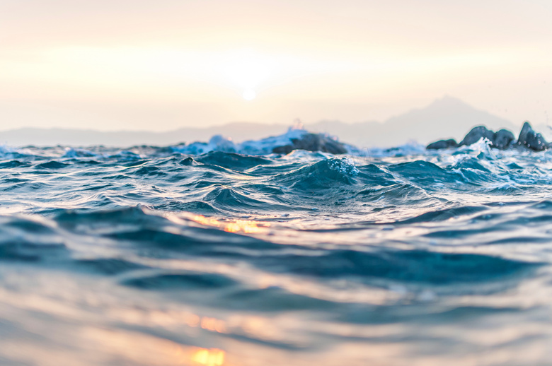 早晨海洋上溅起的浪花摄影图片