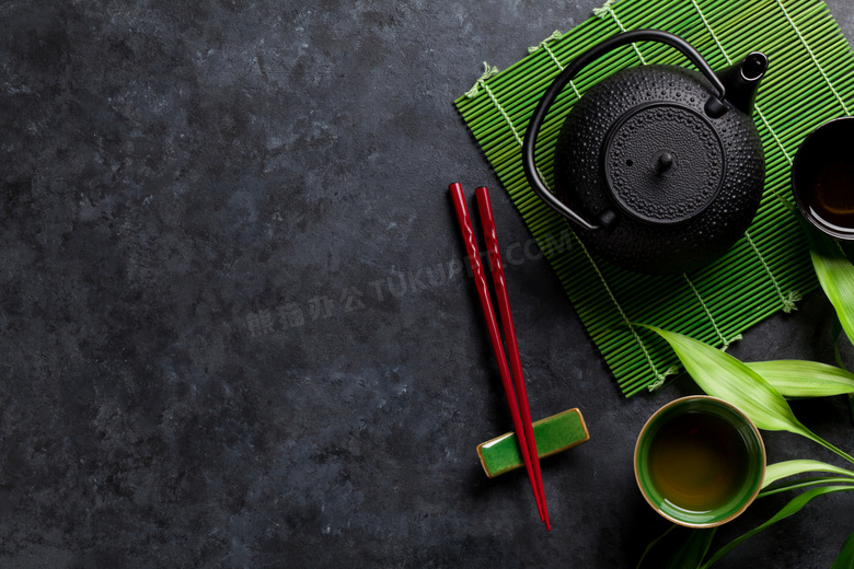 放寿司帘上的黑色茶壶摄影高清图片