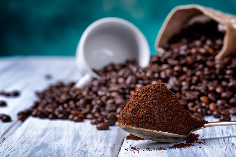 咖啡豆与满满的一汤匙的咖啡粉图片