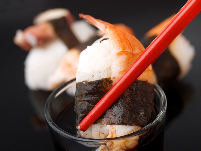 筷子夹起来蘸料的寿司摄影高清图片