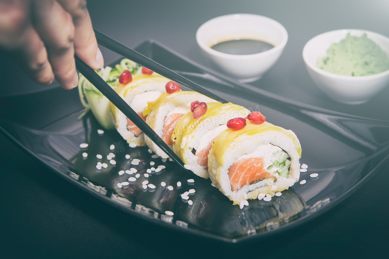 用筷子夹着寿司的情景摄影高清图片