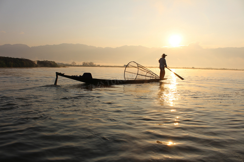 迎着阳光在打渔的渔民摄影高清图片