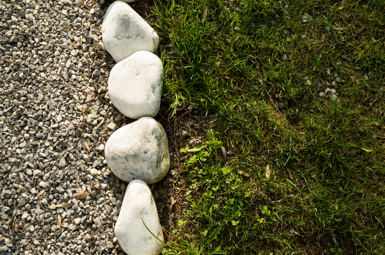 石子路旁的石头与草丛摄影高清图片